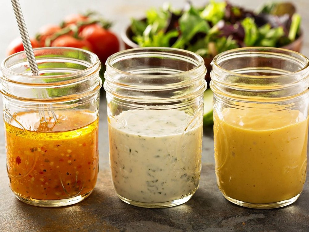 Drei Gläser mit verschiedenem Dressing.