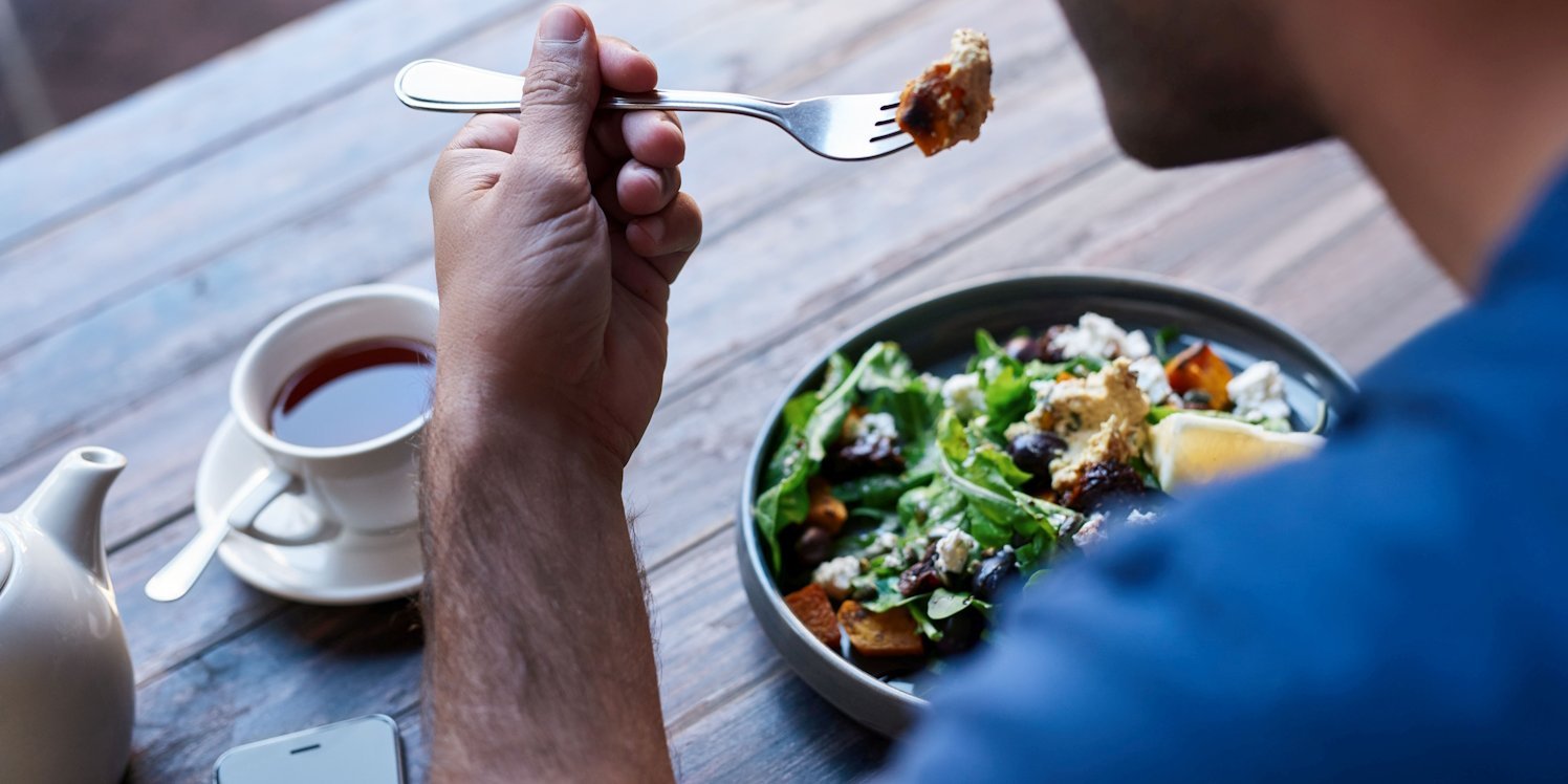 Mann isst Salat.. Artikel "Ernährungspyramide: Mahlzeiten planen und genießen" öffnen.