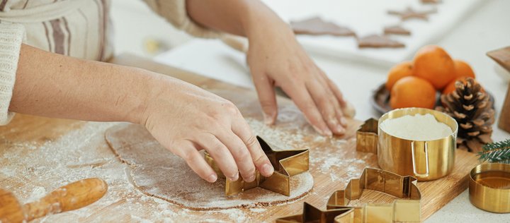 Bemehlte Hand sticht Plätzchen mit Sternenform aus