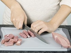 Eine Person schneidet Fleisch.