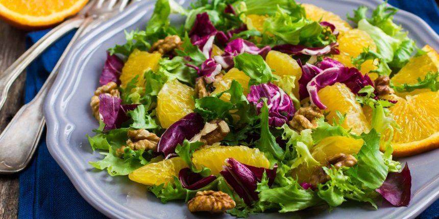 Auf einem grauen Teller liegt ein Salat aus Radicchio, Endivie, Orangenfilets und Walnüssen.. Artikel "Bunte Wintersalate" öffnen.