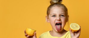 Mädchen mit zwei Zitronen streckt die Zunge raus