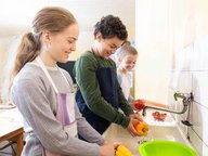 Ein Schüler und eine Schülerin waschen Paprikaschoten .