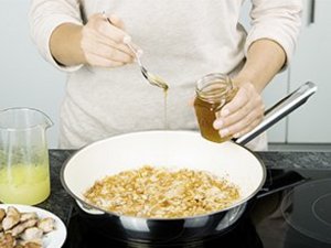 Eine Person brät Zwiebeln an.