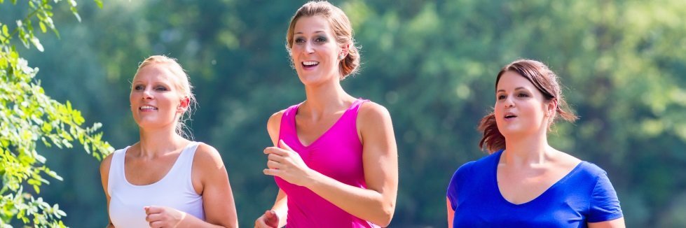 Drei Frauen in Sportkleidung joggen im Freien.