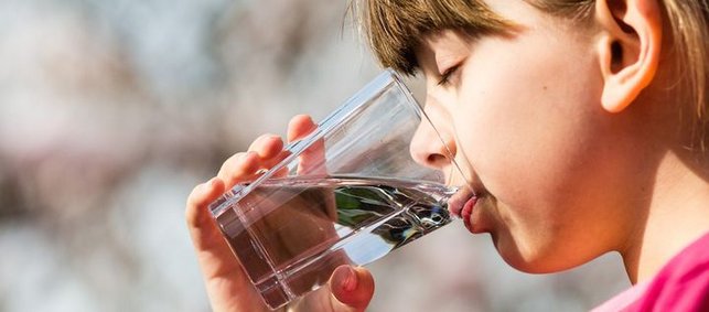 Kind trinkt ein Glas Wasser