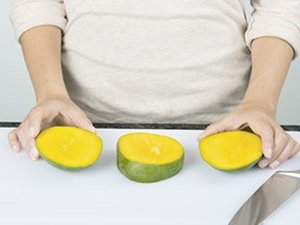 Eine Person teilt Mango.