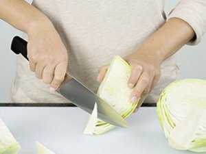 eine Person entfernt den Strunk aus dem Weißkohl.