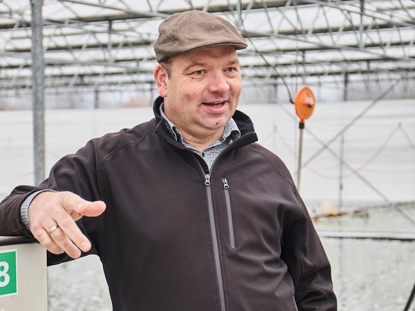 Ein Mann steht in einem Algengewaechshaus.