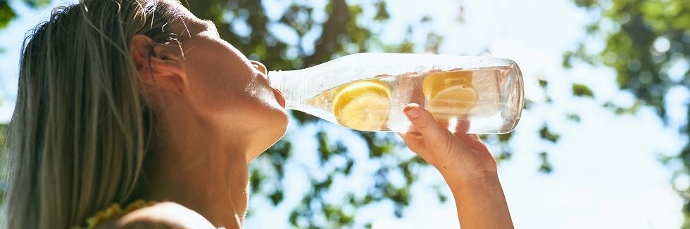 Eine Frau trinkt aus einer Flasche.