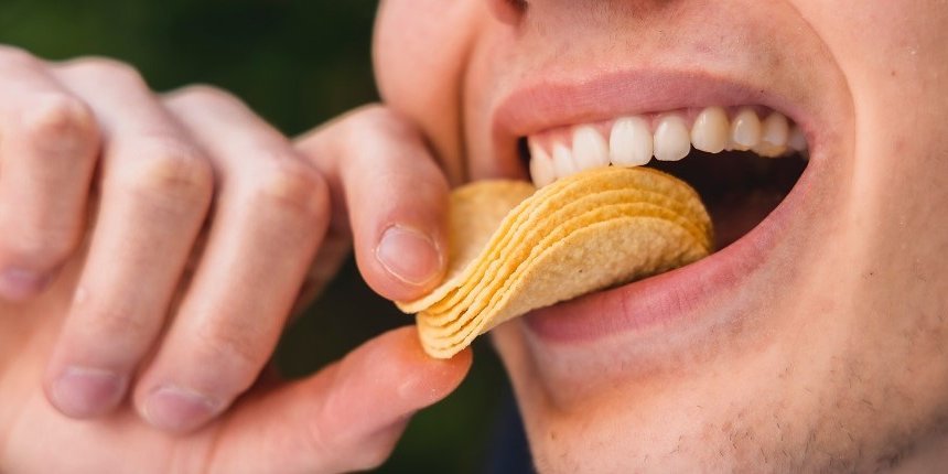 Chips Hand Mund. Artikel "Wenn Teenager ungesund essen" öffnen.