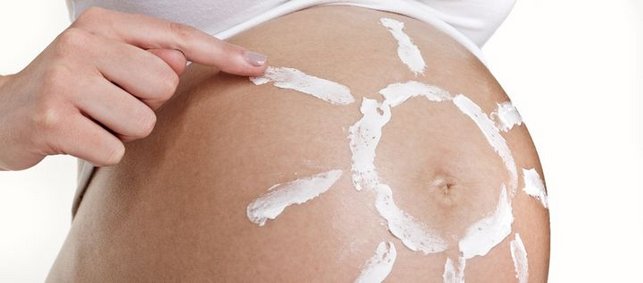 Schwangerenbauch mit gemalter Sonne aus Lotion