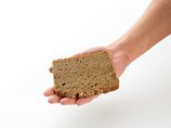 Eine Hand hält eine Scheibe Brot.