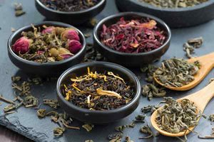 Verschiedene Sorten aromatisierten Tees in Schalen