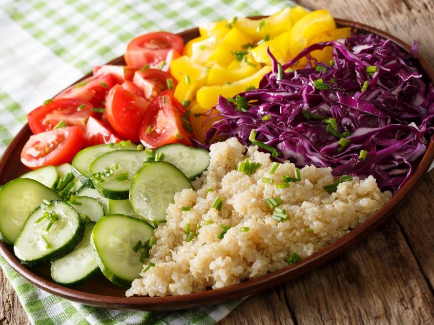 Bunte Rohkost mit Quinoa auf einem ovalen Teller.