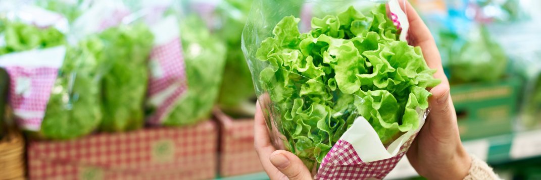 Frau hält einen Lollo bionda vor einem Supermarktregal in der Hand.