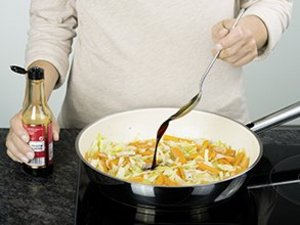 eine Person würzt das Kohlgemüse.