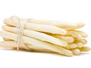 Ein Bund weißer Spargel liegt vor weißem Hintergrund.