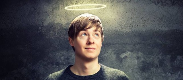 Junger Mann mit Heiligenschein über dem Kopf vor schwarzem Hintergrund