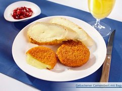 Teller mit zwei Baguettescheiben und zwei gebackene Camembert, dazu Schale mit Preiselbeeren.