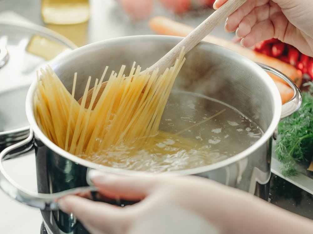 Spaghetti stehen aufrecht in einem Topf mit kochendem Wasser.