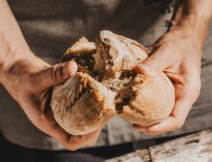 Zwei Hände brechen Brot durch