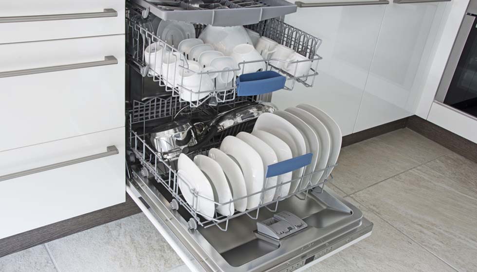 Offene Geschirrspülmaschine mit Geschirr