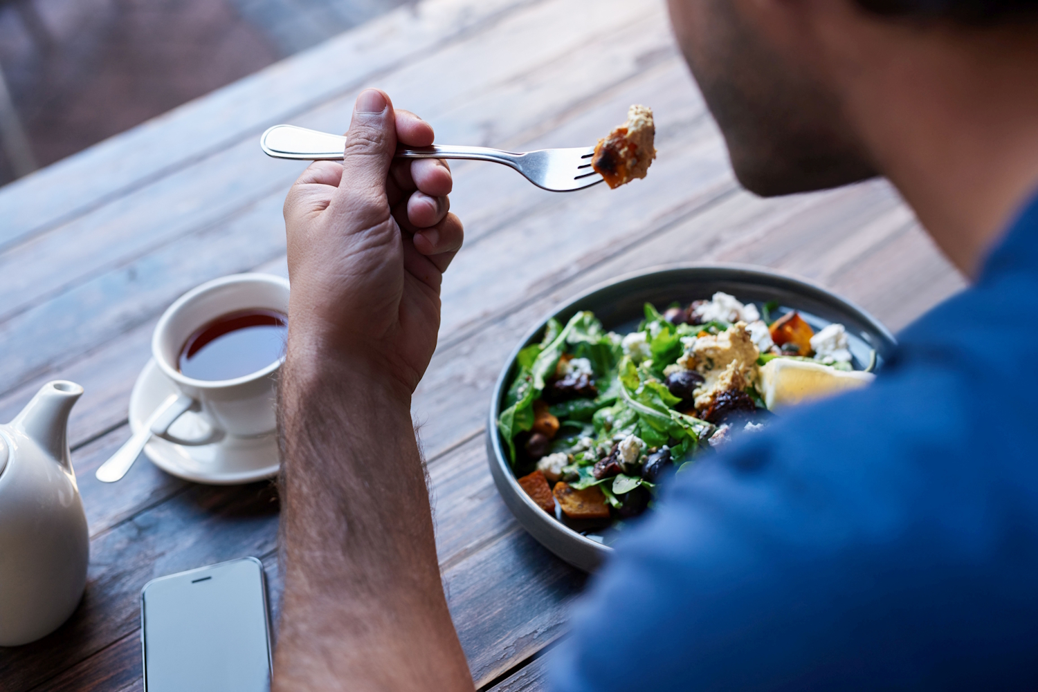 Mann isst Salat.. Artikel "Ernährungspyramide: Mahlzeiten planen und genießen" öffnen.